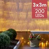 A net of LED lights is displayed on a wall, with bushes and a basket in the foreground. Produktbild-Vorschau