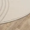 A close-up view of a round rug with a subtle pattern, placed on a wooden floor. Produktbild-Vorschau