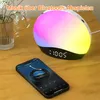 A bedside table with a sunrise alarm clock and a smartphone displaying a music app. Produktbild-Vorschau