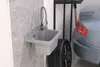 A sink and a car tire in a garage setting. Anteprima dell’immagine prodotto