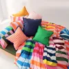 A colorful duvet cover and pillows are arranged on a bed. Voir les images du produit