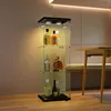 A glass display cabinet with bottles of alcohol on shelves, placed in a room with a table and bench. Produktbild-Vorschau