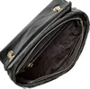 An open black handbag with gold hardware, showing the interior. Produktbild-Vorschau