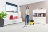 A woman is using a Kärcher carpet cleaner in a living room. Produktbild-Vorschau