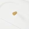 A close-up shot of a white surface with a gold knob or handle. Voir les images du produit