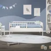 A child's bedroom with a white crib, a rocking chair, and toys. Produktbild-Vorschau