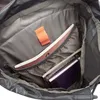 The inside of a backpack with books and a small orange tag. Produktbild-Vorschau