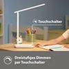 A child's hand is shown touching a desk lamp on a wooden desk, with pencils and an alarm clock nearby. Produktbild-Vorschau