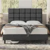 A dark gray upholstered bed frame with a tufted headboard is shown in a bedroom setting with blinds in the background. Produktbild-Vorschau
