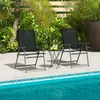 Two black folding chairs and a small table are set up on a patio next to a swimming pool. Náhľad obrázku produktu