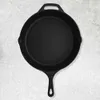 A black cast iron skillet is shown from a top-down view on a textured gray background. Produktbild-Vorschau