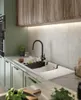 A modern kitchen sink area with a black faucet, white sink, and wooden cabinets. Produktbild-Vorschau