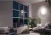A cozy living room corner with a sofa, plants, and a wall lamp. Produktbild-Vorschau