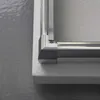 A close-up view of the corner of a shower enclosure, showing the metallic frame and frosted glass. Anteprima dell’immagine prodotto