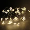 A close-up shot of a string of star-shaped LED lights on a dark, textured surface. Produktbild-Vorschau