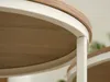 Close-up view of the edge of two round tables with a wood-grain top and white metal frame. Podgląd zdjęcia produktu