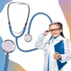 A young girl dressed as a doctor, holding a clipboard and adjusting her glasses, with a stethoscope in the foreground. Anteprima dell’immagine prodotto