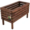 A wooden planter box with legs, shown against a white background. A small tag with an image of two people and text is attached to the side. Anteprima dell’immagine prodotto