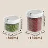 Two clear plastic food storage containers with white lids, one filled with green peas and the other with red beads, with dimensions and volume indicated by text and lines. Produktbild-Vorschau