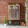 A wooden and polycarbonate mini greenhouse with plants and gardening supplies. Voir les images du produit