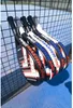 Several padel rackets are leaning against a black net on a blue court. Produktbild-Vorschau
