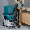 A person is using a circular saw on a workbench, with a vacuum cleaner next to them. Produktbild-Vorschau
