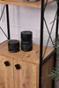 A close-up view of two decorative black marble cylinders on a wooden shelf, part of a bookshelf. Produktbild-Vorschau