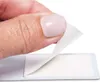 A close-up shot of a finger peeling a white adhesive strip from a backing. Produktbild-Vorschau
