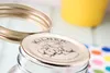 A close-up shot of a Kilner jar lid with a screw band and a yellow object in the background. Podgląd zdjęcia produktu
