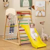 Two children playing on a wooden indoor playground with a slide, climbing net, and ladder. Náhled obrázku produktu