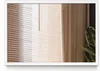 A close-up view of a window with blinds and a curtain, with a plant in the foreground. Produktbild-Vorschau