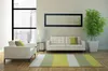 A modern living room with a sofa, armchair, rug, and a large plant. Produktbild-Vorschau
