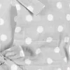Close-up view of a grey fabric with white polka dots, showing stitching and a bow detail. Náhľad obrázku produktu