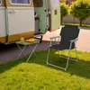 A camping chair and table are set up on the grass next to a camper van. Produktbild-Vorschau