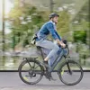 A man is riding an electric bicycle on a street with blurred background. Produktbild-Vorschau