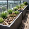 Bunte Kieselsteine in Pflanzkübeln mit Gräsern auf einer Terrasse Produktbild-Vorschau