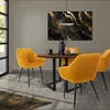 A dining set with four mustard yellow chairs around a round wooden table, with a modern abstract painting on the wall. Produktbild-Vorschau