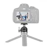 A camera mounted on a mini tripod, showing a family photo on the camera's screen. Produktbild-Vorschau