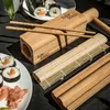 A sushi-making set with sushi rolls and pickled ginger on a dark surface. Náhľad obrázku produktu