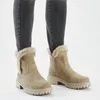 A person wearing grey jeans and beige winter boots. Anteprima dell’immagine prodotto