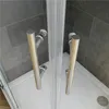 Close-up view of a shower cabin's corner with chrome handles and glass doors. Produktbild-Vorschau