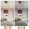 A bedroom scene with a modern ceiling lamp shown in two states: on and off. The lamp is square with a black frame and a white light element. The bed is made with neutral-toned bedding and pillows, and there is artwork on the wall above the headboard. The t Voir les images du produit