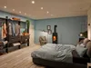 A bedroom with a bed, wardrobe, and a wood-burning stove. Anteprima dell’immagine prodotto