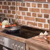 A kitchen counter with a stovetop, cooking utensils, and ingredients. Produktbild-Vorschau