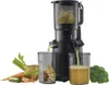 A black juicer with ingredients and juice on a white background. Podgląd zdjęcia produktu