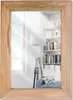 A mirror with a wooden frame reflects a room with bookshelves, a lamp, and a sofa. Produktbild-Vorschau