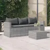 An outdoor patio scene with a grey rattan sofa and coffee table set against a backdrop of lush greenery and a decorative screen. Produktbild-Vorschau