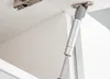 Close-up of a gas strut attached to a cabinet, likely for a kitchen. Náhled obrázku produktu