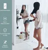A woman is brushing her hair in front of a full-length mirror, with text overlays describing the mirror's features. Náhled obrázku produktu