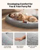 A woman and a dog are lying on a large, plush dog bed. Voir les images du produit